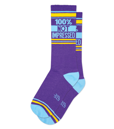 Purple sock with light blue accents and text "100% NOT IMPRESSED" on the cuff.