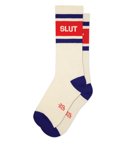 Natural cotton sock with cream accents, red band reading "SLUT," blue heel and toe, no background.