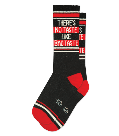 Black socks with red accents and text: "THERE'S NO TASTE LIKE BAD TASTE." Red heel and toe.